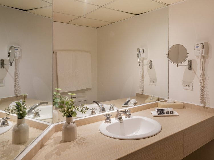 Bathroom sink, mirror and amenities in a King Room at Stanza Hotel CDMX