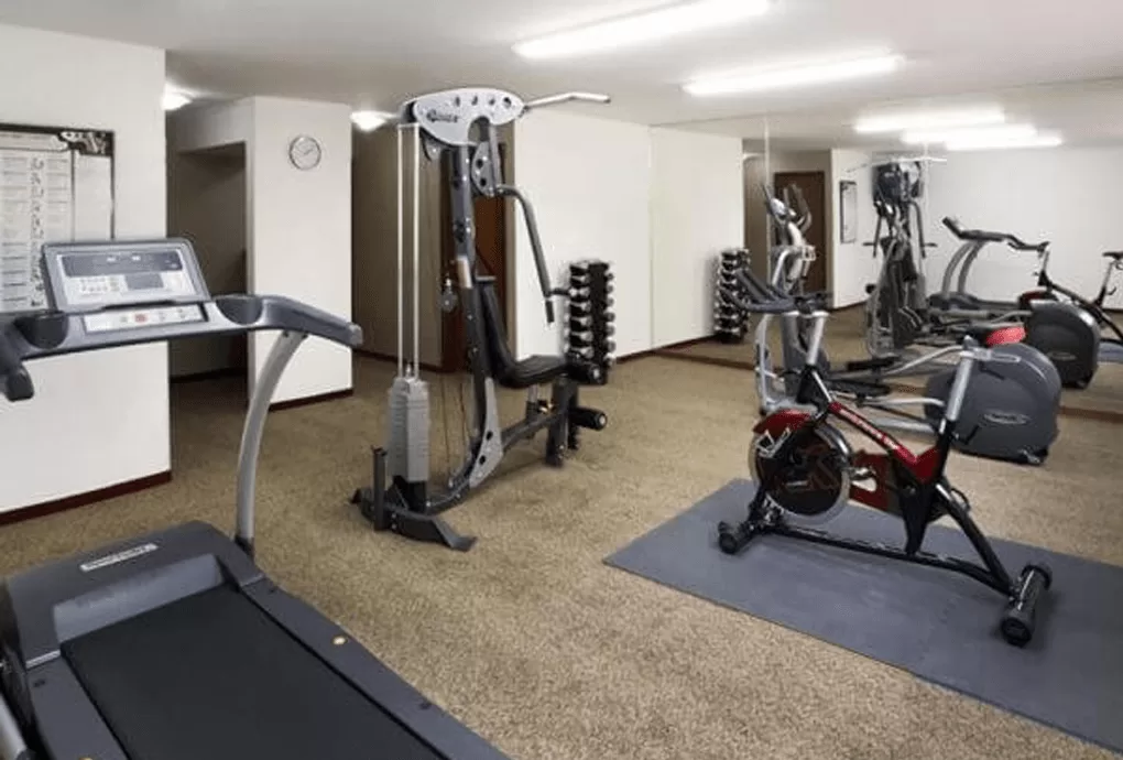 Gimnasio de Stanza Hotel en la Colonia Roma, equipado con caminadora, bicicleta de spinning, mancuernas y aparatos de ejercicio.