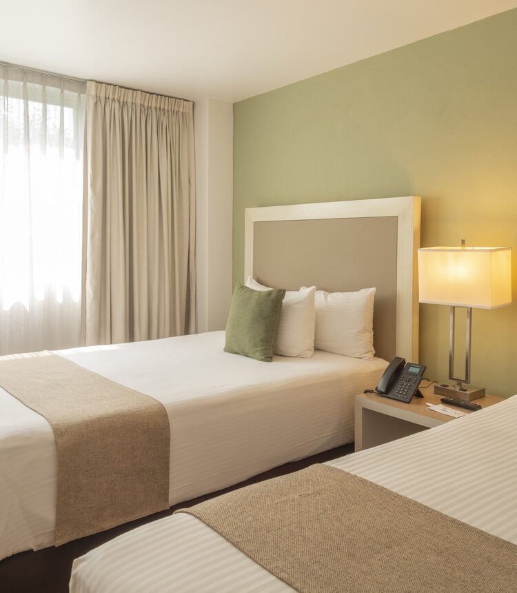 Cama matrimonial junto a ventana en Habitación Doble de Stanza Hotel CDMX