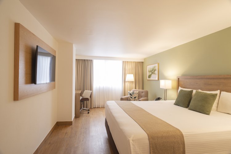 Vista completa de Habitación King con cama, televisión y escritorio en Stanza Hotel CDMX