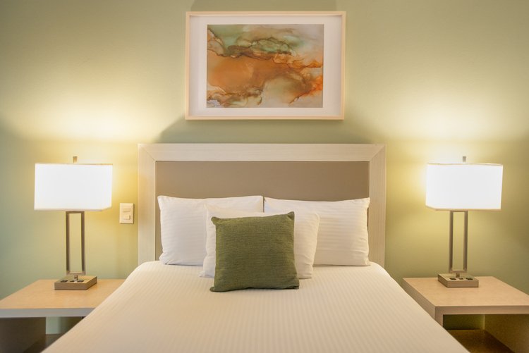 Cama matrimonial con lámparas laterales en Habitación Sencilla de Stanza Hotel CDMX