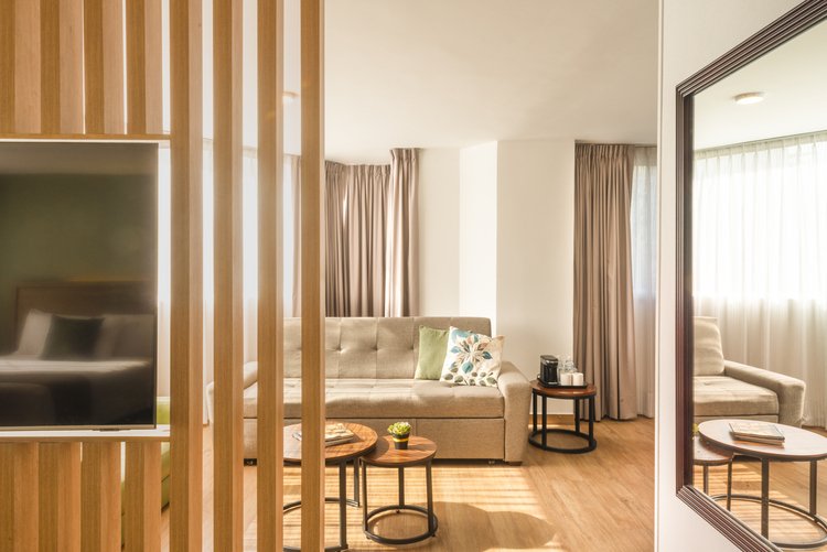 Suite King de Stanza Hotel CDMX con sala, televisión y una cama king size