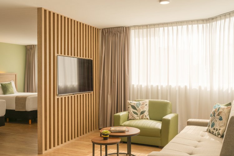Suite Doble de Stanza Hotel CDMX con sala, televisión y dos camas matrimoniales