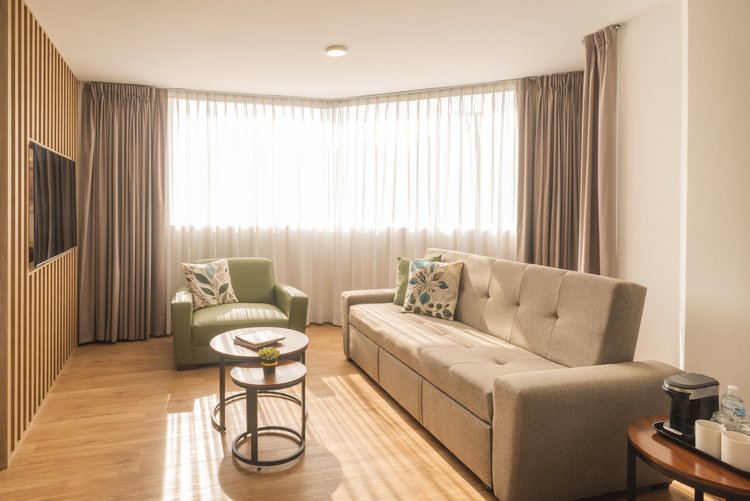 Sala con sofá y sillón en Suite Doble de Stanza Hotel CDMX