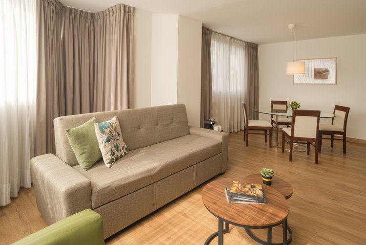 Sala amplia con sofá y sillón en Suite Doble de Stanza Hotel CDMX